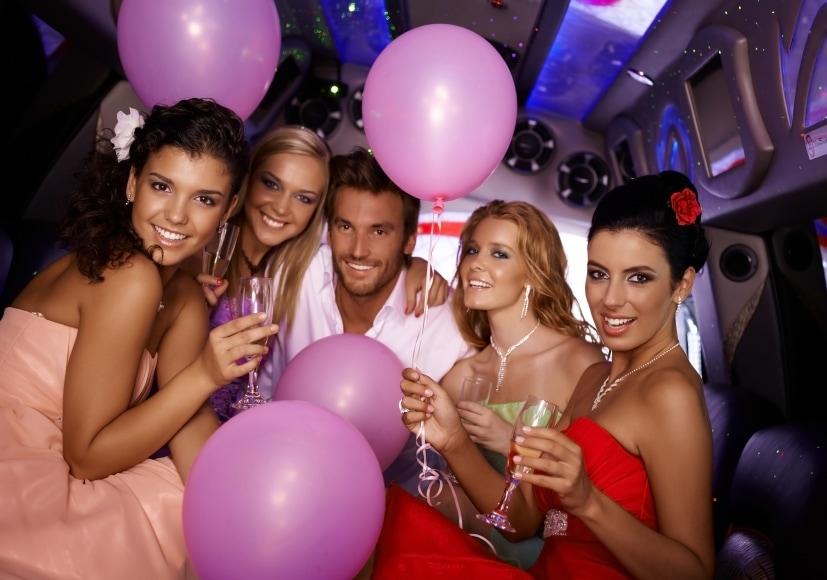 A group of young partiers celebrating a birthday party in a luxurious limousine