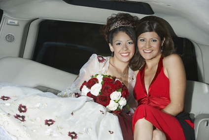 Friends celebrate a quinceanera by riding in a limo from mass to the party venue