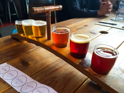 A flight of beers sits at the ready for someone to taste